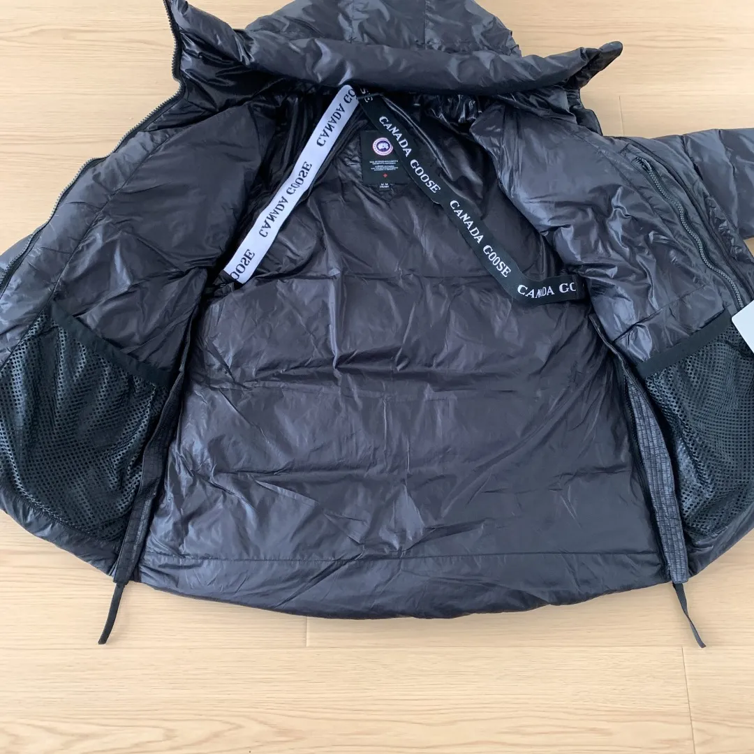 Style number: Y 166 2239L women's model (high version) Canada goose Cypress down jacket Cypress Series' New Arrival allows you to show your difference. This down jacket is an ideal winter piece. This style is filled with white duck down. Featuring a thin, channel-filled construction with lightweight fabrics and trim, it feels lightweight and adds warmth. The suede knit stand-up collar that protects the chin is soft and adds comfort. An adjustable down hood with cord closure adds warmth and protection against the elements. The back is designed with the iconic double-stripe Black reflective decorative stripes, making you more visible in dim environments. The inner layer has removable elastic straps, making the jacket easy to carry on the shoulder and hands-free. The side zipper gusset is breathable when moving. Color: Black Red Label Silver Birch Size: XS-2XL